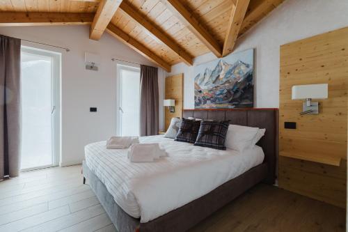 a bedroom with a large bed in a room with wooden ceilings at PINZOLO MOUNTAIN LODGE in Pinzolo