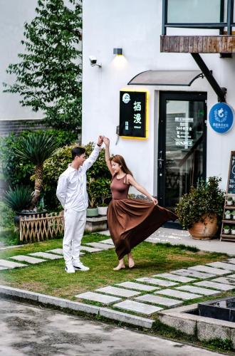 a man and a woman are holding hands in front of a building at Heaven's Gate Lodge XMAN-Free pick up in Zhangjiajie
