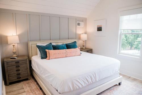 a bedroom with a white bed with blue pillows at Kaya Cottages in Dahlonega