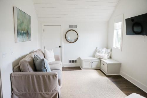 a white living room with a couch and a mirror at Kaya Cottages in Dahlonega