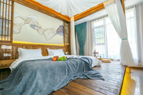 a bedroom with a bed with fruit on it at Pure House in Zhangjiajie