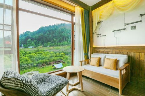 a room with a window with a couch and a chair at Pure House in Zhangjiajie