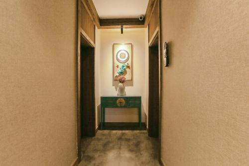a hallway with a table and a picture on the wall at Pure House in Zhangjiajie