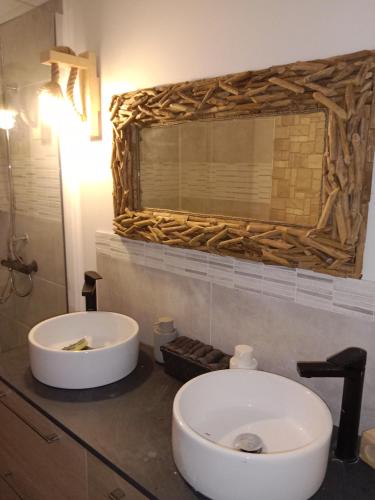 une salle de bain avec un lavabo blanc et un miroir dans l'établissement opale passion France, à Ruoms