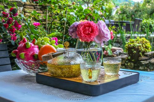 a tray with a vase of flowers on a table at Pure House in Zhangjiajie