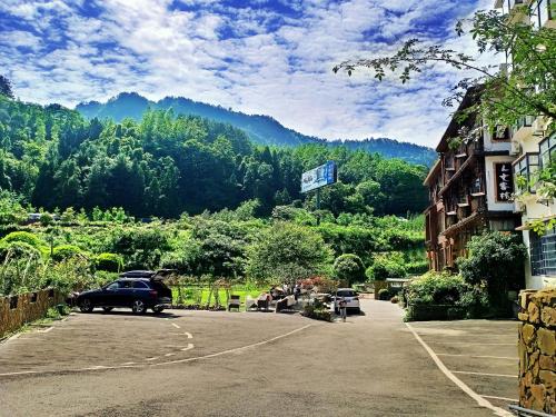 a car parked in a parking lot in front of a mountain at Pure House in Zhangjiajie