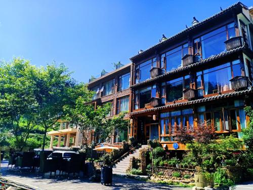 a building with tables and chairs in front of it at Pure House in Zhangjiajie