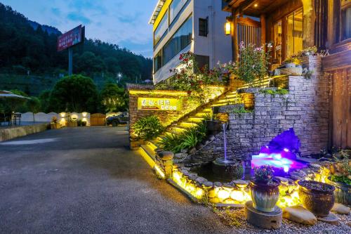 a stone building with a fire place in a courtyard at Pure House in Zhangjiajie