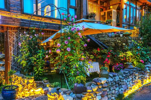 a garden with flowers and plants in front of a building at Pure House in Zhangjiajie