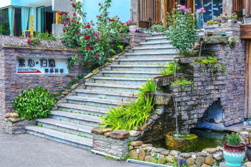 a set of stairs with flowers and plants on them at Pure House in Zhangjiajie