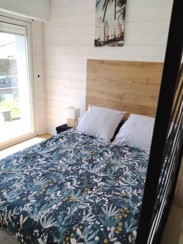 un lit dans une petite maison avec une grande fenêtre dans l'établissement Chez Cristele et David, à Capbreton