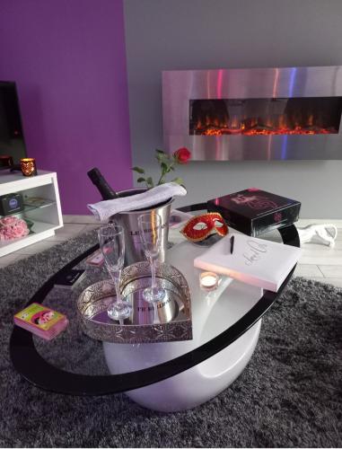 - une table dans une pièce avec cheminée dans l'établissement Le Sensuel, à Isigny-sur-Mer