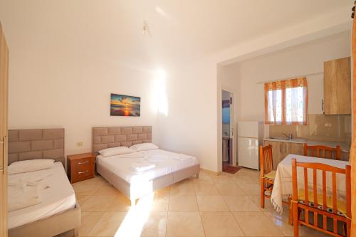 a bedroom with two beds and a kitchen in it at Vila Dura in Ksamil