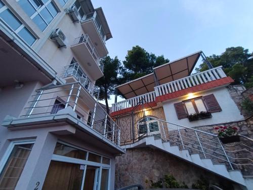 a white building with stairs and a balcony at Aparthotel Villa Maja in (( Gornji Sušanj ))