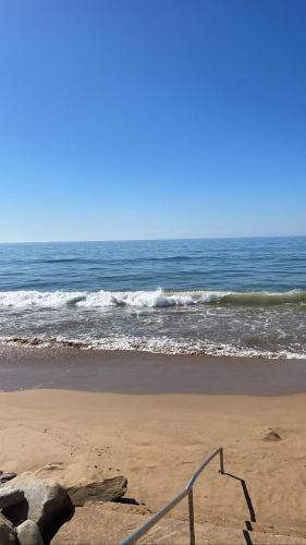 a sandy beach with the ocean in the background at Surf Appartement pied dans l eau 10 min d Agadir in Aourir