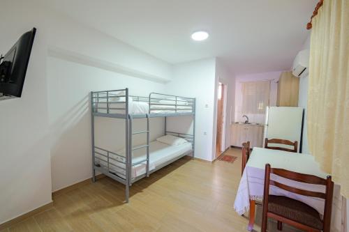 a room with two bunk beds and a table at Vila Dura in Ksamil