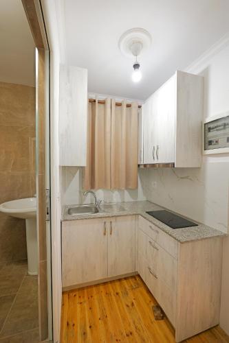 a kitchen with white cabinets and a sink at Vila Dura in Ksamil