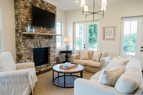 a living room with white furniture and a fireplace at Kaya Cottages in Dahlonega