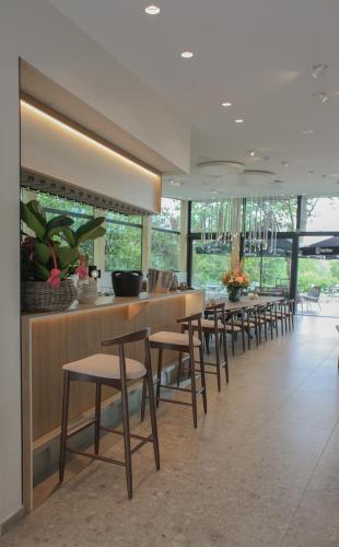 a row of tables and chairs in a restaurant at Hôtel Les Fines Gueules in Herve