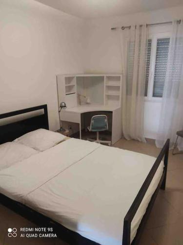 une chambre avec un lit et un bureau avec un ordinateur dans l'établissement Appart T3 avec jardin proche commerces et aéroport, à Borgo