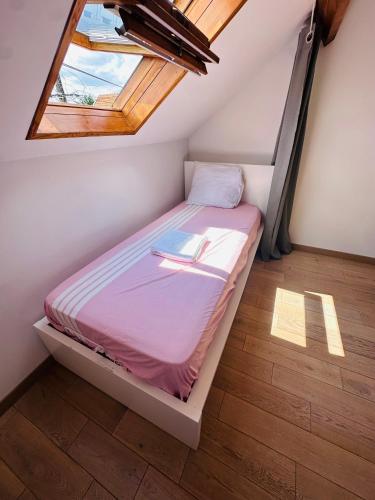 a bed in a room with a window at Lit Style Dortoir dans un Maison in Bezons