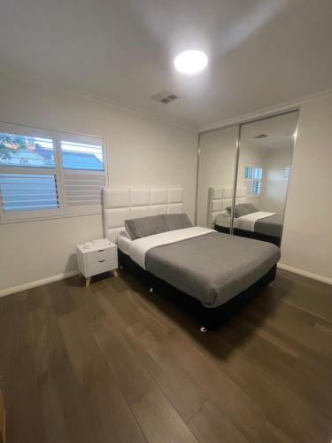 1 dormitorio con cama y espejo en Modern room in Perth city !!, en Perth