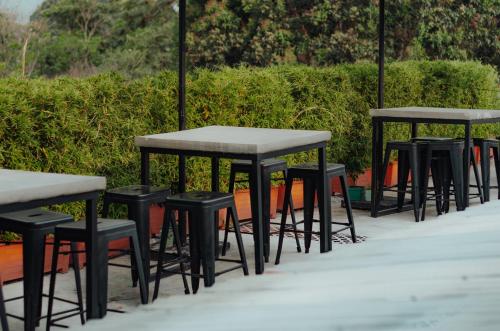 a row of tables and stools in front of a hedge at Selah Hotel & Coffee in Antigua Guatemala
