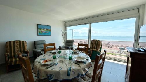 une salle à manger avec une table et une vue sur la plage dans l'établissement Appt avec vue EXCEPTIONNELLE sur la baie + garage, au Crotoy
