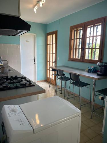 une cuisine avec des murs bleus et un comptoir avec des chaises dans l'établissement Notreve, à Lorgues