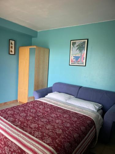 une chambre avec un lit et un mur bleu dans l'établissement Notreve, à Lorgues