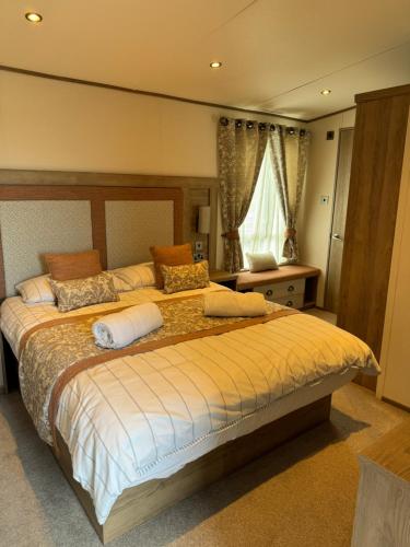 sypialnia z dużym łóżkiem i oknem w obiekcie 2-6 guests Holiday Home in Durdle Door w mieście Wareham