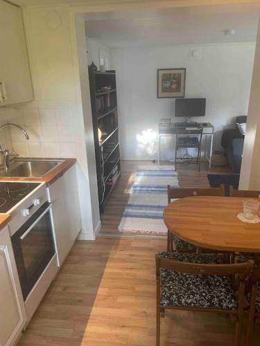 a kitchen and dining room with a table and a dining room at Ängelsbäcksstugan in Båstad