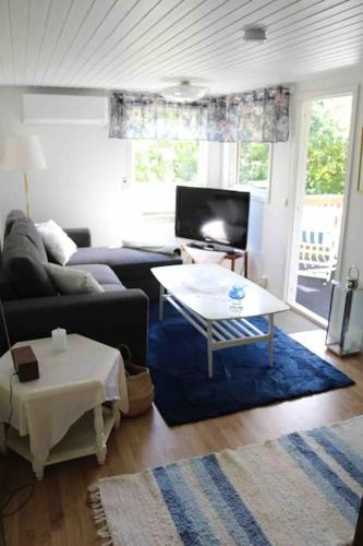 a living room with a couch and a table at Ängelsbäcksstugan in Båstad