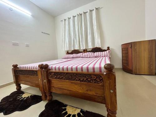 a bedroom with a wooden bed with a window at San Service Apartment by Dolfy in Kelambākkam