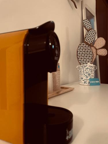 a coffee maker on a counter next to a vase at Casa Mia in Mola di Bari
