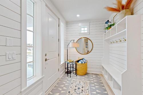 a hallway with white walls and a door and a mirror at Ocean Pearl at Palmilla Beach in Port Aransas