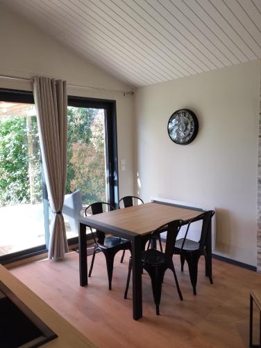 une table à manger avec des chaises et une horloge murale dans l'établissement GITE O Petits OIGNONS, aux Herbiers