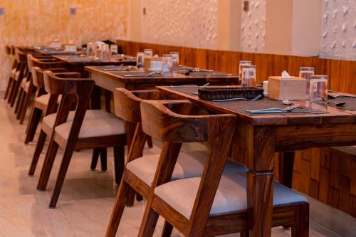 a row of wooden tables and chairs in a room at Pine Tree Resort in Nagarkot