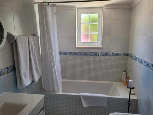 Un baño blanco con bañera y ventana. en Vila Johanna, en Lagos