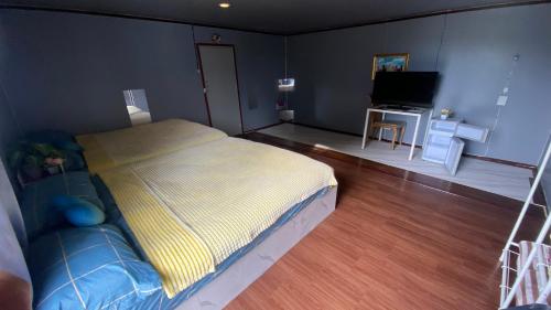 a bedroom with a bed and a couch and a television at อุ่นฟ้าอิงดาว ริมน้ำ1 in Wang Nam Khieo