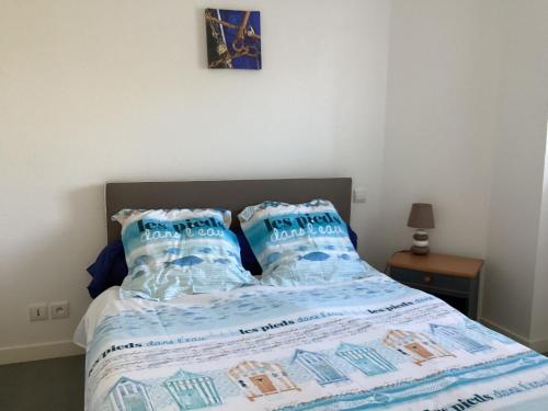 - un lit avec des oreillers bleus au-dessus dans l'établissement Appartement avec piscine proche thalasso et plages, à Carnac