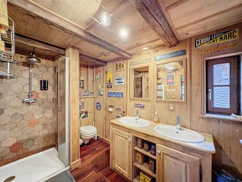 ein Badezimmer mit zwei Waschbecken, einem WC und einer Badewanne in der Unterkunft Gîte Le Chut - Piscine chauffée - 11 à 14 personnes in Rangen