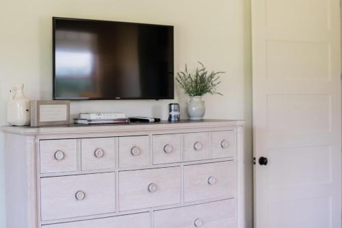 a dresser with a television on top of it at Kaya Cottages in Dahlonega