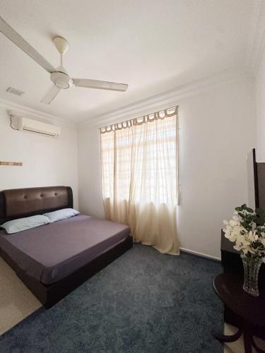 een slaapkamer met een bed en een raam bij Anna Homestay in Kuala Terengganu