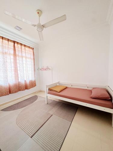 een slaapkamer met een bed en een tapijt bij Anna Homestay in Kuala Terengganu