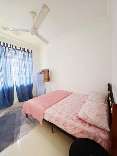 een slaapkamer met een bed met een roze deken bij Anna Homestay in Kuala Terengganu
