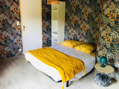 une chambre avec un lit avec une couverture jaune dans l'établissement Maison 3 chambres - Chez Florence, à Yzeure