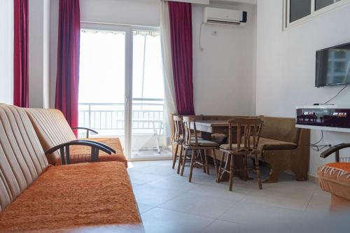 a living room with a couch and a table with chairs at BluApartments 3,Shëngjin Seaview in Shëngjin