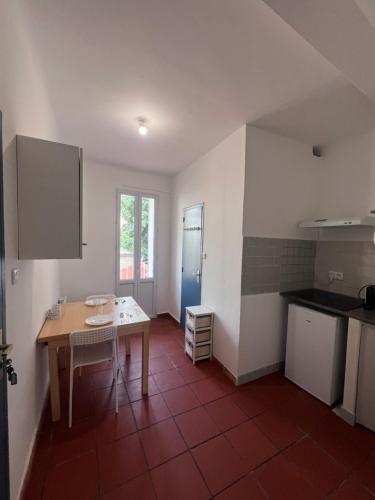 une cuisine avec une table et une porte bleue dans l'établissement Appartement T1 bis, à Toulon