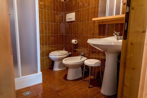 a bathroom with two toilets and a sink at Residence Des Alpes in Asiago